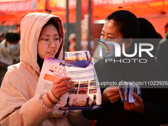 Job seekers are learning about job openings at a booth of an employment company at a spring job fair for SMEs in Liaocheng, China, on Februa...