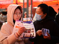 Job seekers are learning about job openings at a booth of an employment company at a spring job fair for SMEs in Liaocheng, China, on Februa...