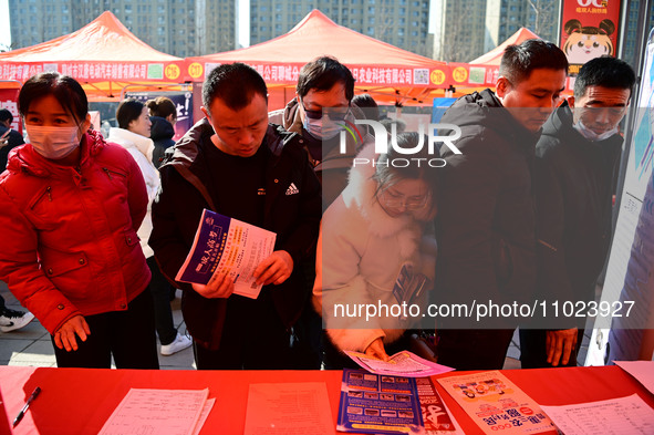 Job seekers are learning about job openings at a booth of an employment company at a spring job fair for SMEs in Liaocheng, China, on Februa...