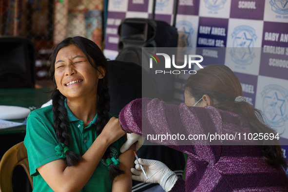 A Nepali student is reacting as a paramedic administers a vaccine against measles-rubella at a local school in Kathmandu, Nepal, on February...