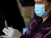 A Nepali paramedic is preparing a dose of the anti-measles-rubella vaccine as she gets ready to administer it during the nationwide vaccinat...