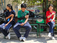 Nepali students are sitting on a bench after being administered vaccines against measles and rubella in Kathmandu, Nepal, on February 25, 20...