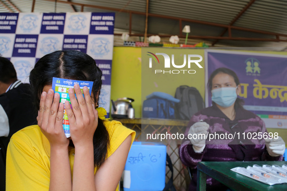 A Nepali student is reacting as a paramedic administers a vaccine against measles-rubella at a local school in Kathmandu, Nepal, on February...