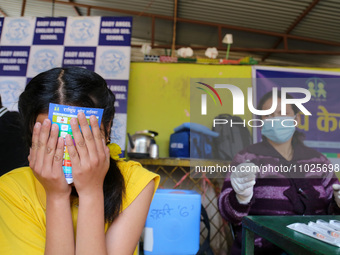 A Nepali student is reacting as a paramedic administers a vaccine against measles-rubella at a local school in Kathmandu, Nepal, on February...