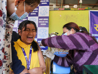 A Nepali student is reacting as a paramedic administers a vaccine against measles-rubella at a local school in Kathmandu, Nepal, on February...