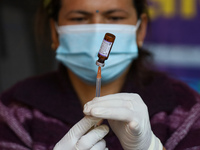 A Nepali paramedic is preparing a dose of the anti-measles-rubella vaccine as she gets ready to administer it during the nationwide vaccinat...