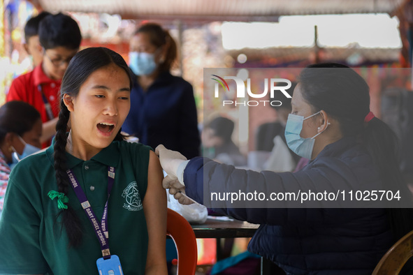 A Nepali student is reacting as a paramedic administers a vaccine against measles-rubella at a local school in Kathmandu, Nepal, on February...