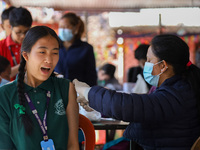 A Nepali student is reacting as a paramedic administers a vaccine against measles-rubella at a local school in Kathmandu, Nepal, on February...