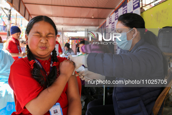 A Nepali student is reacting as a paramedic administers a vaccine against measles-rubella at a local school in Kathmandu, Nepal, on February...