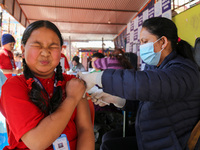 A Nepali student is reacting as a paramedic administers a vaccine against measles-rubella at a local school in Kathmandu, Nepal, on February...