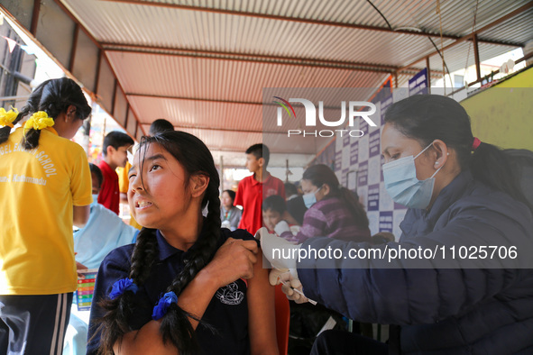 A Nepali student is reacting as a paramedic administers a vaccine against measles-rubella at a local school in Kathmandu, Nepal, on February...