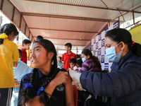 A Nepali student is reacting as a paramedic administers a vaccine against measles-rubella at a local school in Kathmandu, Nepal, on February...