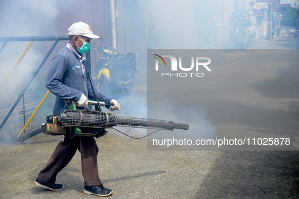 A worker is fumigating an area with anti-mosquito fog to control dengue fever in a residential area in Bogor, West Java, Indonesia, on Febru...