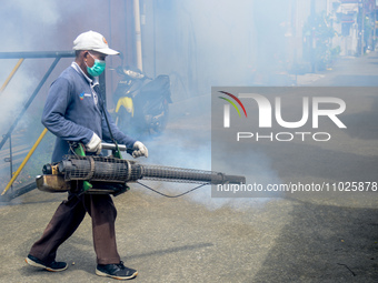 A worker is fumigating an area with anti-mosquito fog to control dengue fever in a residential area in Bogor, West Java, Indonesia, on Febru...