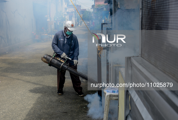 A worker is fumigating an area with anti-mosquito fog to control dengue fever in a residential area in Bogor, West Java, Indonesia, on Febru...