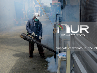 A worker is fumigating an area with anti-mosquito fog to control dengue fever in a residential area in Bogor, West Java, Indonesia, on Febru...