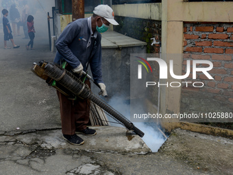 A worker is fumigating an area with anti-mosquito fog to control dengue fever in a residential area in Bogor, West Java, Indonesia, on Febru...