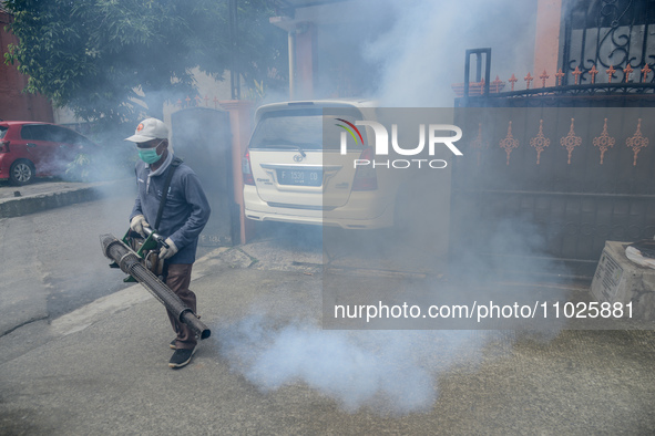 A worker is fumigating an area with anti-mosquito fog to control dengue fever in a residential area in Bogor, West Java, Indonesia, on Febru...