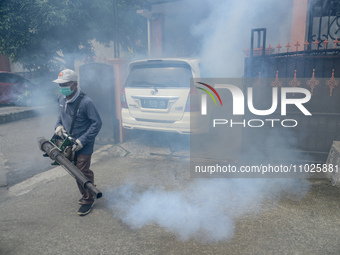 A worker is fumigating an area with anti-mosquito fog to control dengue fever in a residential area in Bogor, West Java, Indonesia, on Febru...