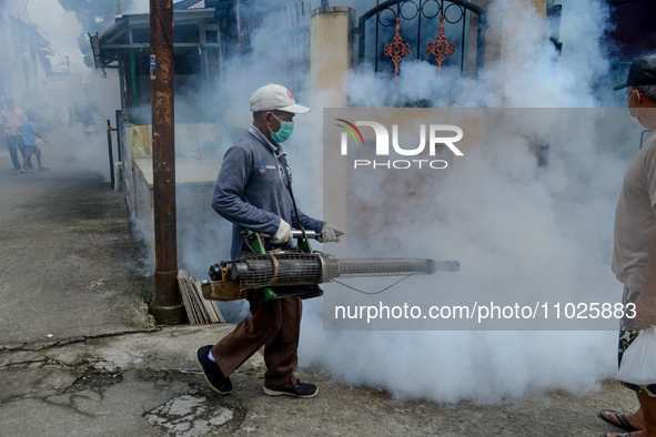 A worker is fumigating an area with anti-mosquito fog to control dengue fever in a residential area in Bogor, West Java, Indonesia, on Febru...