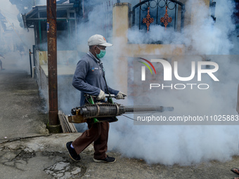 A worker is fumigating an area with anti-mosquito fog to control dengue fever in a residential area in Bogor, West Java, Indonesia, on Febru...