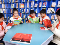 Primary school students are reading red books in Zaozhuang, East China's Shandong province, on February 26, 2024. (