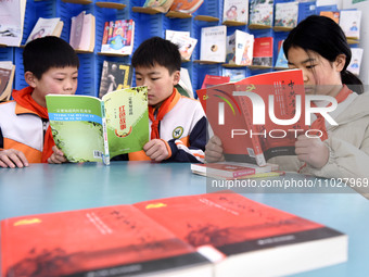 Primary school students are reading red books in Zaozhuang, East China's Shandong province, on February 26, 2024. (