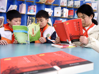 Primary school students are reading red books in Zaozhuang, East China's Shandong province, on February 26, 2024. (