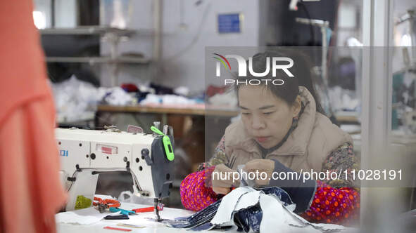 A worker is producing children's clothing products at a workshop of a children's clothing manufacturer in Binzhou, China, on February 26, 20...