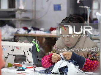 A worker is producing children's clothing products at a workshop of a children's clothing manufacturer in Binzhou, China, on February 26, 20...