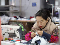 A worker is producing children's clothing products at a workshop of a children's clothing manufacturer in Binzhou, China, on February 26, 20...