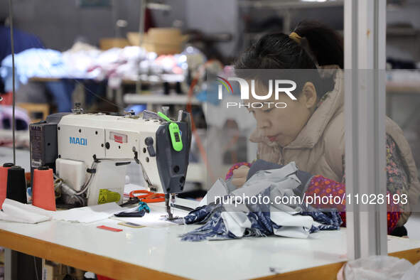 A worker is producing children's clothing products at a workshop of a children's clothing manufacturer in Binzhou, China, on February 26, 20...