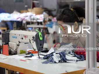 A worker is producing children's clothing products at a workshop of a children's clothing manufacturer in Binzhou, China, on February 26, 20...