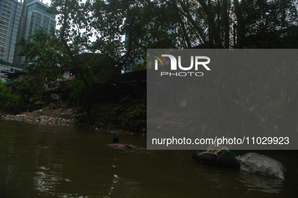 Plastic waste scavengers are collecting debris in the Babura River, which is polluted by plastic waste, in Medan, North Sumatra, Indonesia,...