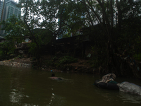 Plastic waste scavengers are collecting debris in the Babura River, which is polluted by plastic waste, in Medan, North Sumatra, Indonesia,...