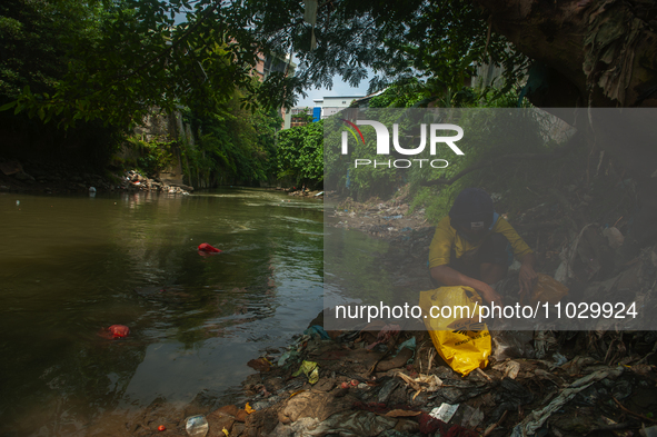 Plastic waste scavengers are collecting debris in the Babura River, which is polluted by plastic waste, in Medan, North Sumatra, Indonesia,...