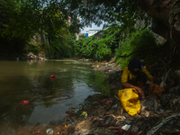 Plastic waste scavengers are collecting debris in the Babura River, which is polluted by plastic waste, in Medan, North Sumatra, Indonesia,...