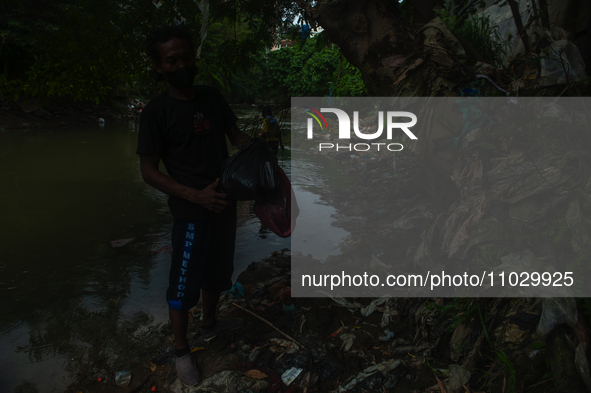 Plastic waste scavengers are collecting debris in the Babura River, which is polluted by plastic waste, in Medan, North Sumatra, Indonesia,...