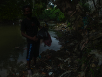 Plastic waste scavengers are collecting debris in the Babura River, which is polluted by plastic waste, in Medan, North Sumatra, Indonesia,...