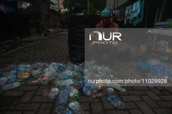 Plastic waste scavengers are collecting debris in the Babura River, which is polluted by plastic waste, in Medan, North Sumatra, Indonesia,...