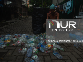 Plastic waste scavengers are collecting debris in the Babura River, which is polluted by plastic waste, in Medan, North Sumatra, Indonesia,...