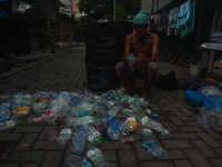 Plastic waste scavengers are collecting debris in the Babura River, which is polluted by plastic waste, in Medan, North Sumatra, Indonesia,...