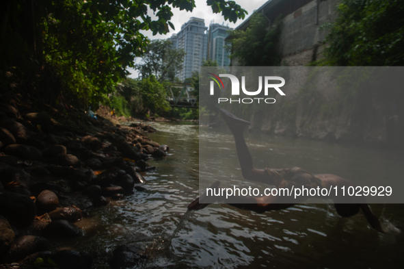 Children are playing in the polluted Babura River, which is contaminated with plastic waste, in Medan, North Sumatra, Indonesia, on February...