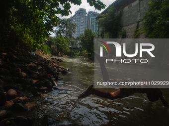 Children are playing in the polluted Babura River, which is contaminated with plastic waste, in Medan, North Sumatra, Indonesia, on February...