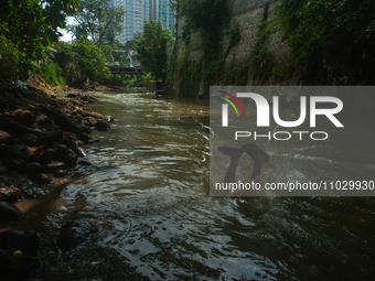 Children are playing in the polluted Babura River, which is contaminated with plastic waste, in Medan, North Sumatra, Indonesia, on February...