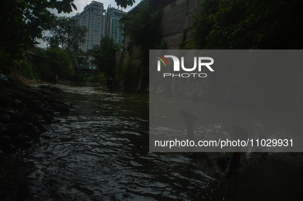 Children are playing in the polluted Babura River, which is contaminated with plastic waste, in Medan, North Sumatra, Indonesia, on February...