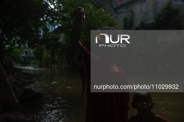 Children are playing in the polluted Babura River, which is contaminated with plastic waste, in Medan, North Sumatra, Indonesia, on February...