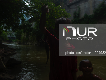 Children are playing in the polluted Babura River, which is contaminated with plastic waste, in Medan, North Sumatra, Indonesia, on February...