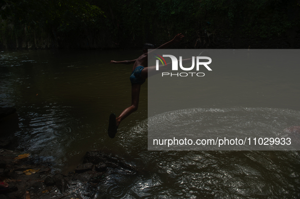 Children are playing in the polluted Babura River, which is contaminated with plastic waste, in Medan, North Sumatra, Indonesia, on February...