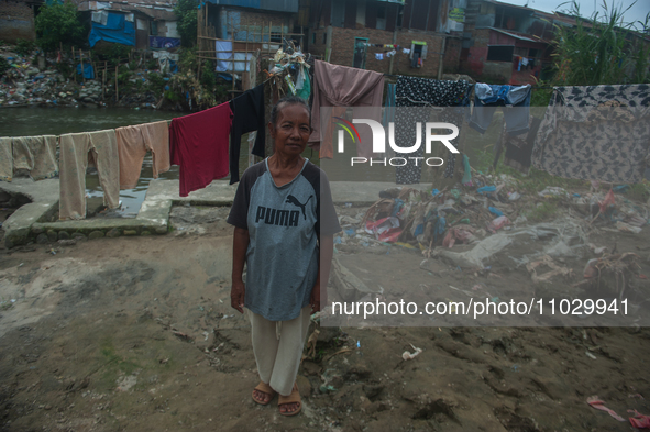 A resident is standing on the banks of the Deli River, which is polluted with plastic waste following floods, in Medan, North Sumatra, Indon...